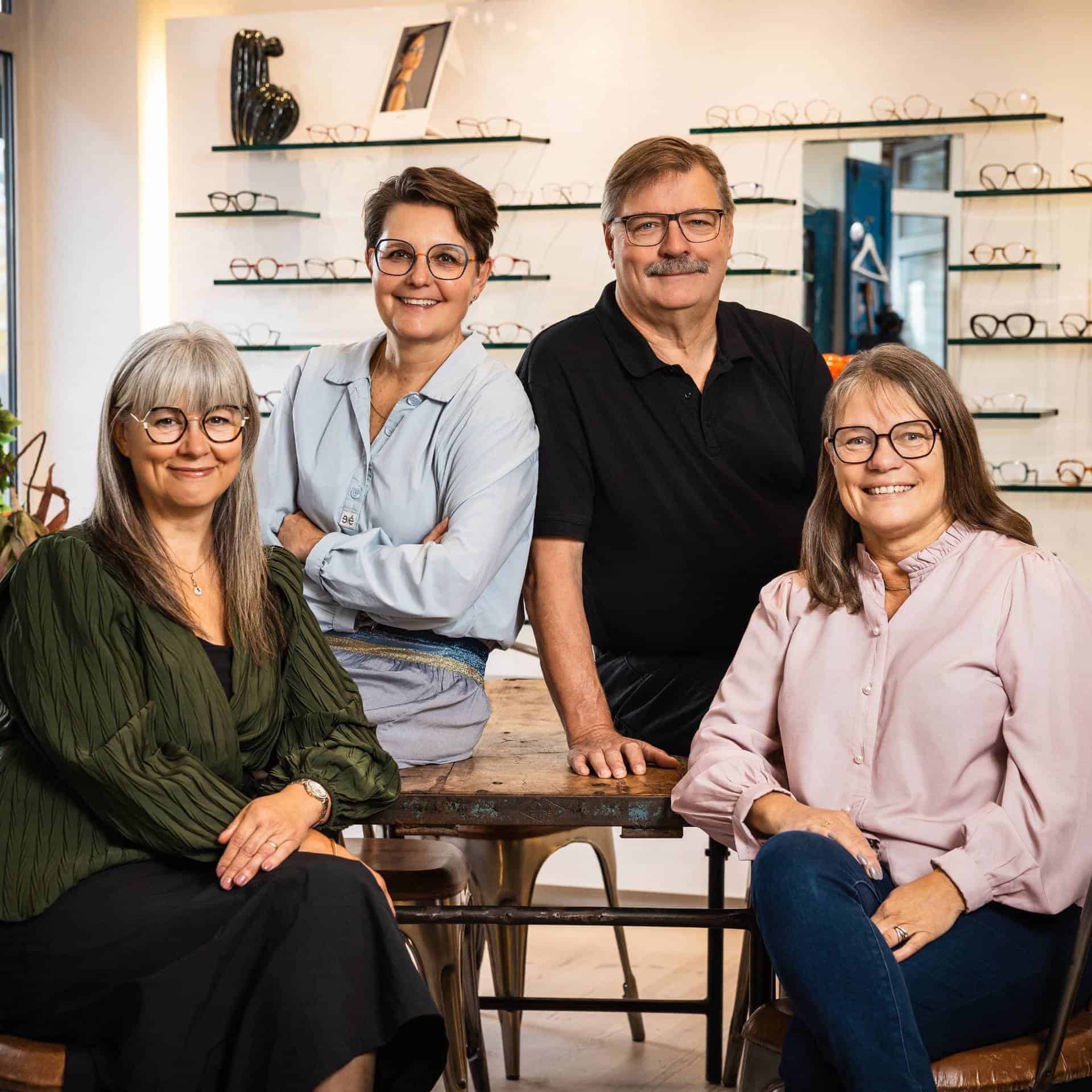 Personalet hos No. 1 Optik samlet i optikerbutikken med brillestel i baggrunden